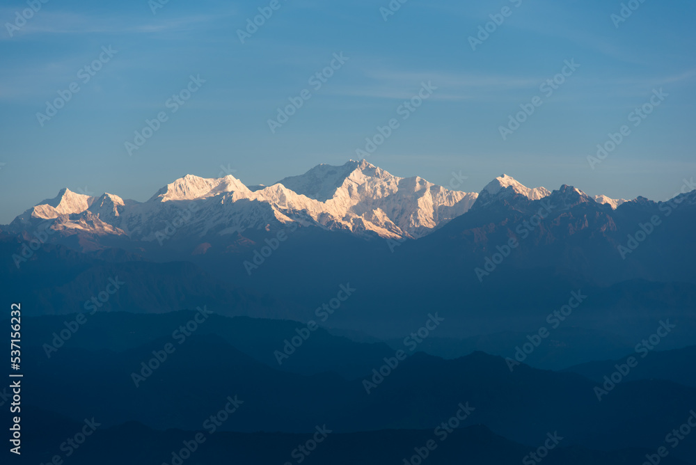Snow capped mountain peaks in the morning light. Close up, selective focus.
