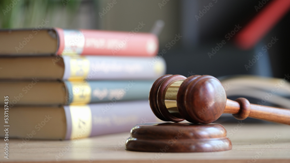 Judge gavel on wooden sounding block and pile of law books Judge gavel on wooden sounding block and pile of law books