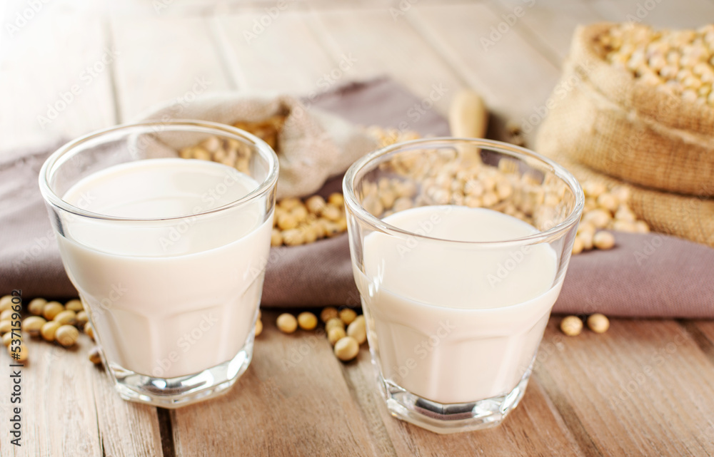 Soy milk in a glass with soybeans on a wooden table organic drink high protein healthy breakfast agricultural produce vegetarian - top view Soy milk in a glass with soybeans on a wooden table organic drink high protein healthy breakfast agricultural produce vegetarian - top view