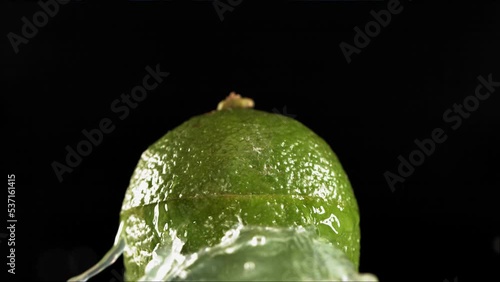 Half Lime falling and splashing on white background. Food levitation concept. Slow Motion photo