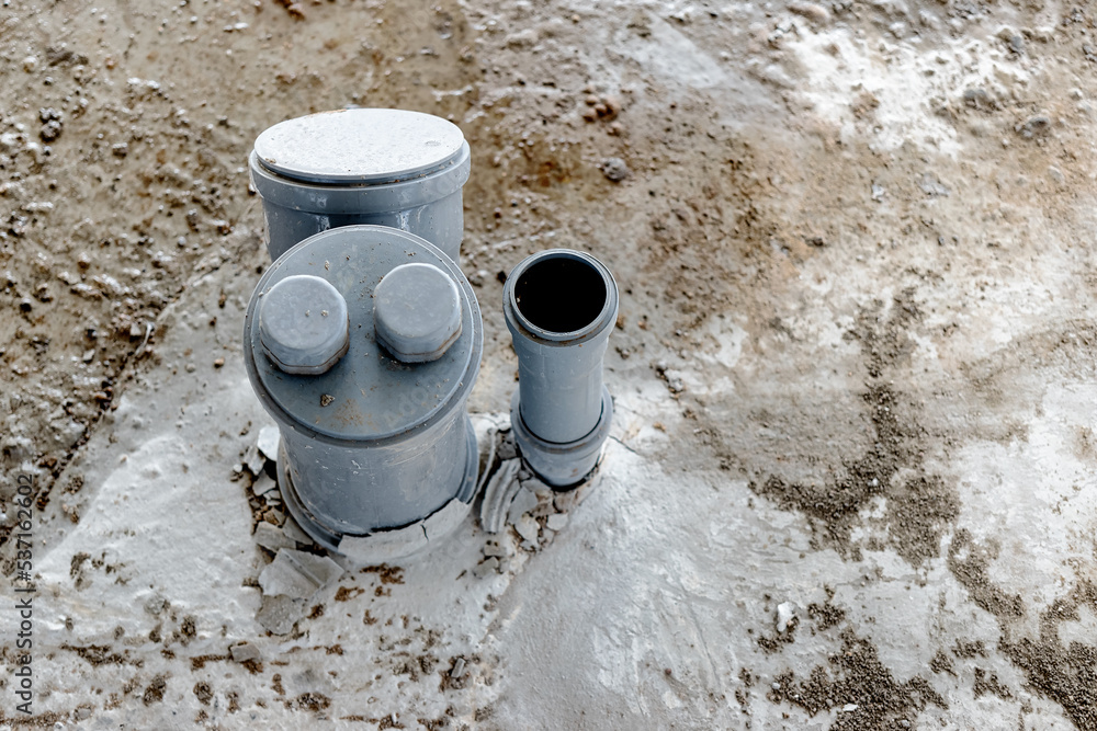 Sewer pipes in home basement. System of gray sanitary pipes in old house. Sewer pipes in home basement. System of gray sanitary pipes in old house.