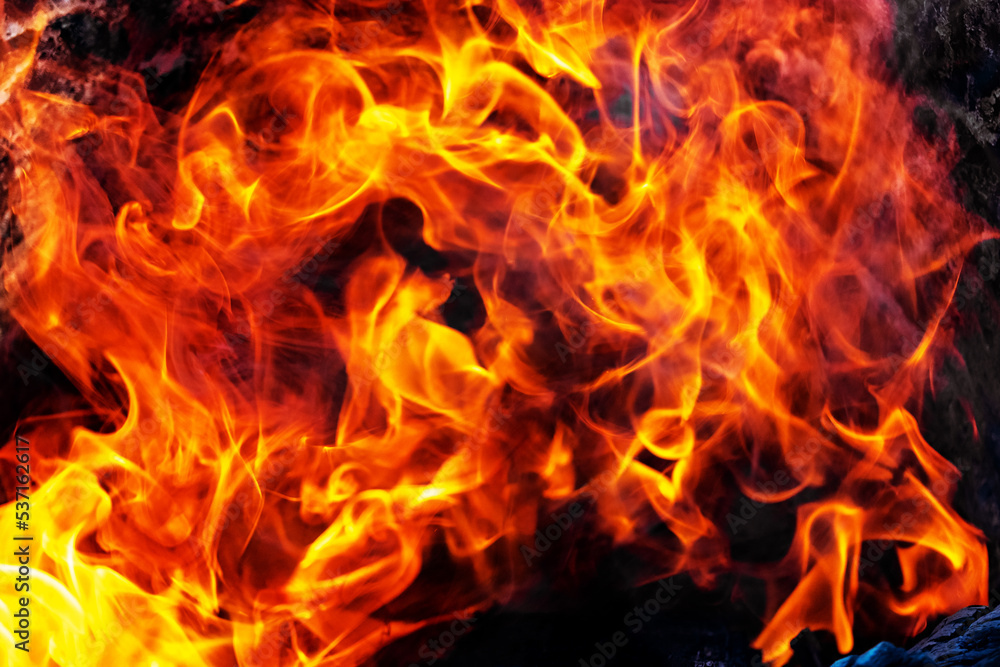 Burning fire close up. Bright orange and red flames on a dark background. Open flame heating. Problems with heating and gas.