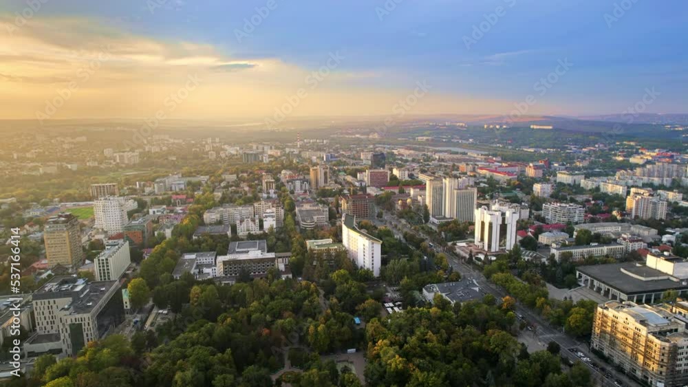 Aerial drone view of Chisinau at sunset, Moldova. View of city centre with presidency and parliament, multiple buildings, roads, lush greenery, cityscape Aerial drone view of Chisinau at sunset, Moldova. View of city centre with presidency and parliament, multiple buildings, roads, lush greenery, cityscape
