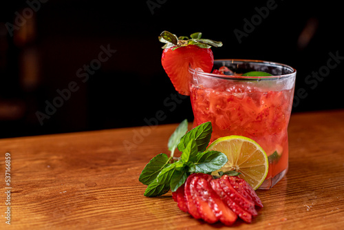 Coloridas bebidas refrescantes para el verano, jugo frío de limonada de fresa con cubitos de hielo en vasos adornados con limones frescos en rodajas photo