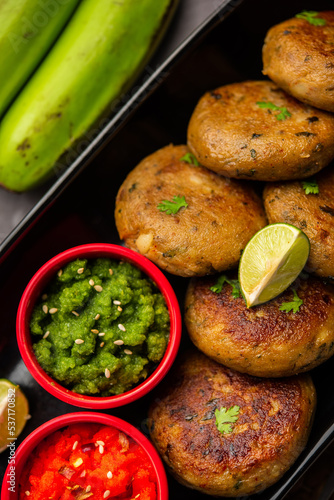 Raw Banana Cutlet also called plantain or kacche kele ki tikki or patties, served with chutney photo