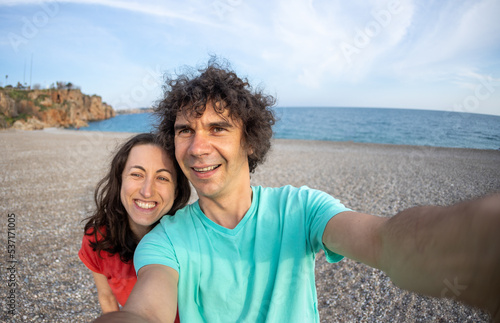 A man and a woman take a selfie on the seashore
