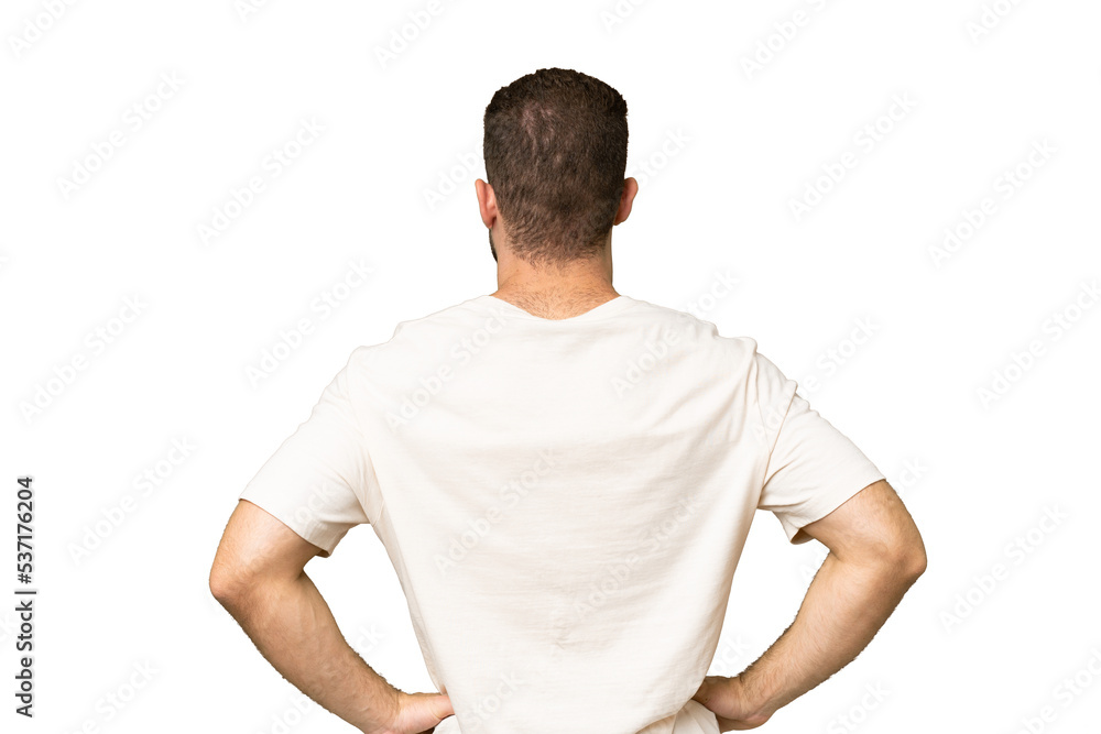 Young handsome caucasian man isolated on green chroma background in back position Young handsome caucasian man isolated on green chroma background in back position