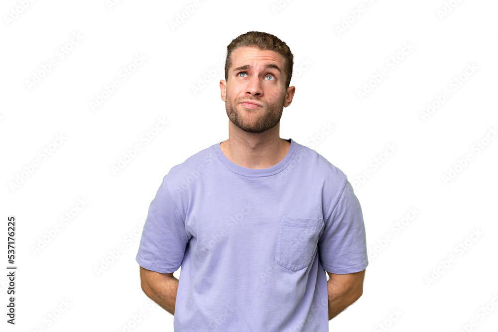 Young handsome caucasian man isolated on green chroma background and looking up Young handsome caucasian man isolated on green chroma background and looking up