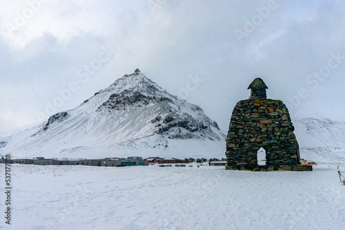 Saga of Barour Snaefellsas Statue at Arnarstapi town during winter snow everning at Arnarstapi , Snæfellsnes peninsula in Iceland : 15 March 2020 photo
