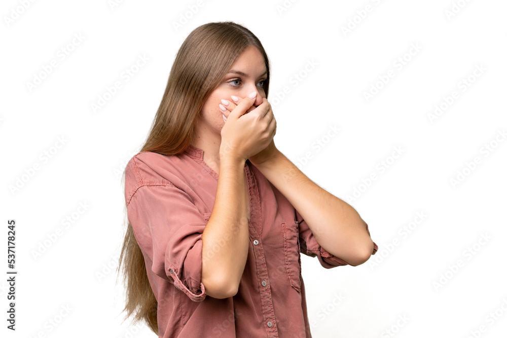 Young beautiful blonde woman over isolated background covering mouth and looking to the side Young beautiful blonde woman over isolated background covering mouth and looking to the side
