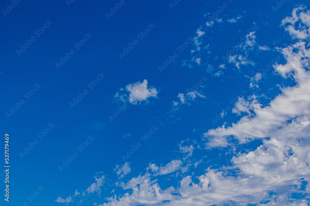 natural blue sky on a sunny day with white wispy clouds background