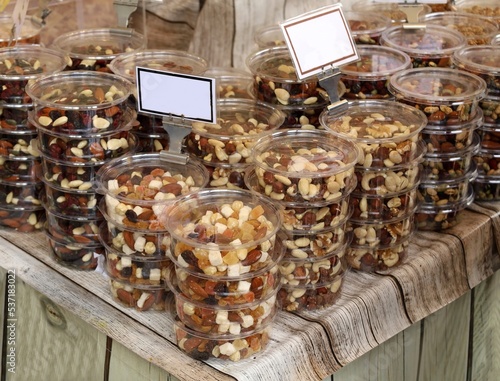 Energy snacks with nuts and dried fruits in plastic containers on the store shelf