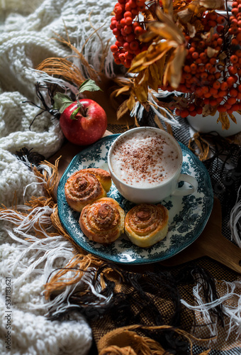 Cozy morning - cappuccino, cinnamon rolls, cozy blankets. Autumn mood home