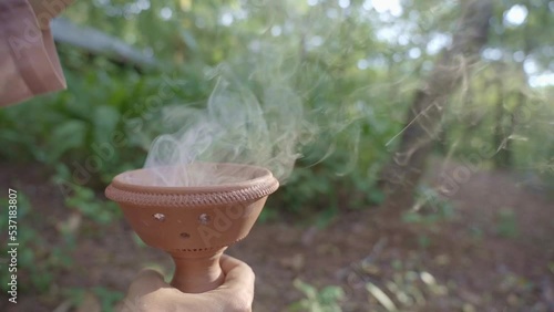 Close up of Asian female hands infusing sambrani Benzoin for air purification in Yoga forest retreat at Goa India photo
