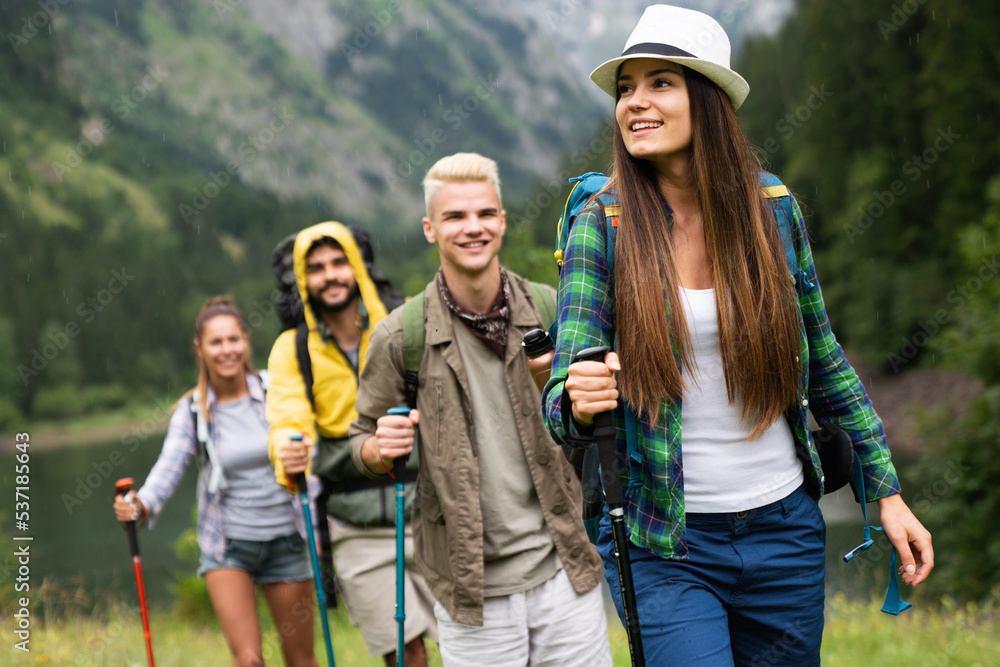 Group of happy fit friends hiking, trekking together outdoor nature Group of happy fit friends hiking, trekking together outdoor nature