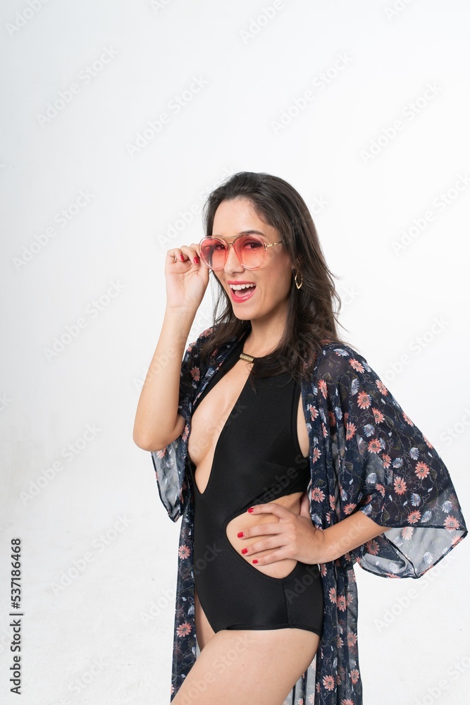 Studio portrait photo of a young beautiful elegant Brazilian female model lady wearing black color swimsuit bikini, sunglasses and beach scarf posing with a series moments of emotion and gesture Studio portrait photo of a young beautiful elegant Brazilian female model lady wearing black color swimsuit bikini, sunglasses and beach scarf posing with a series moments of emotion and gesture