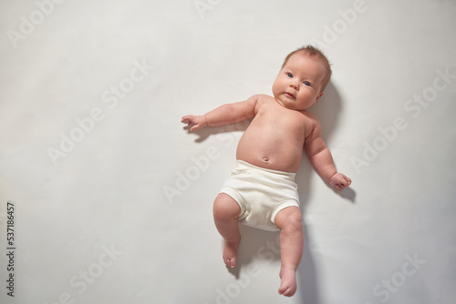 A newborn baby lying full-length on a light-colored surface