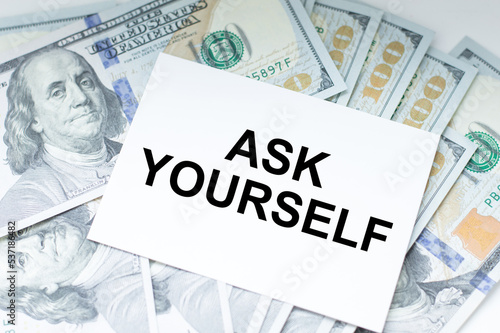 A white card with the text Ask Yourself on the table