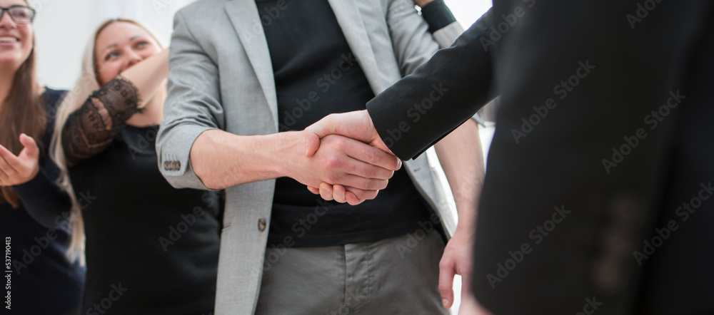 close up. employees congratulating their colleague on success and victory.