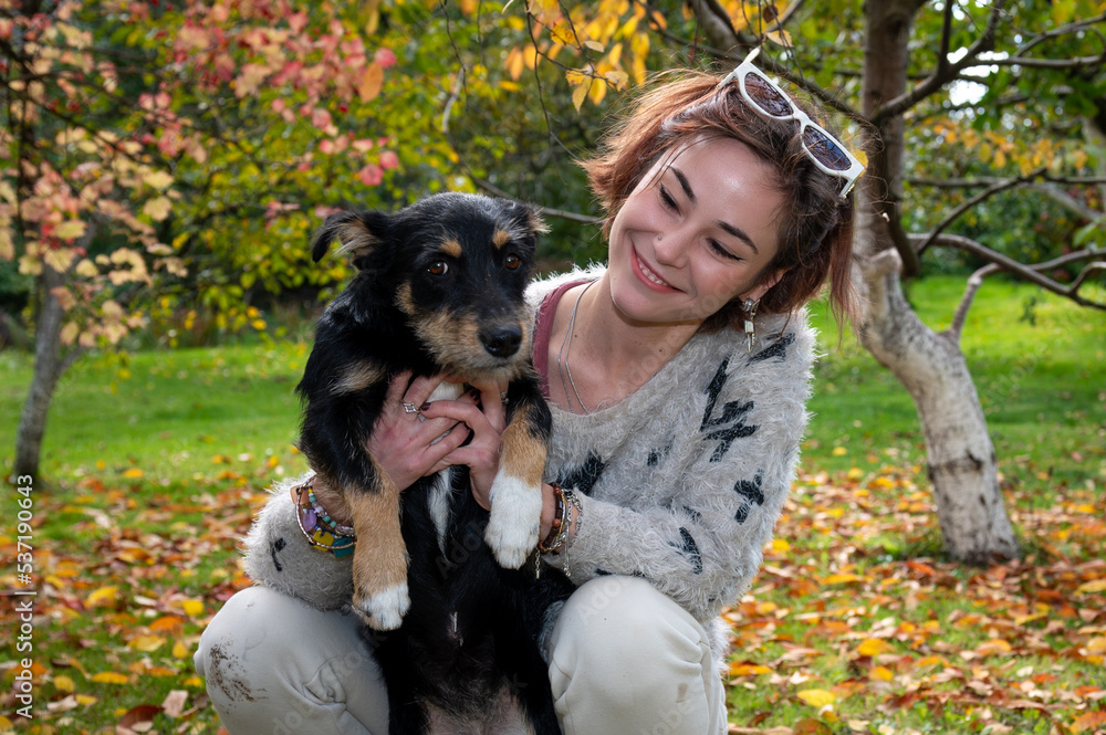 Smiling woman with dog in autumn park. Portrait of happy young woman with dog outdoors in autumn Smiling woman with dog in autumn park. Portrait of happy young woman with dog outdoors in autumn