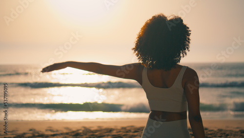 Yoga girl practicing gomukhasana on beach closeup. Woman stretching arms sunrise