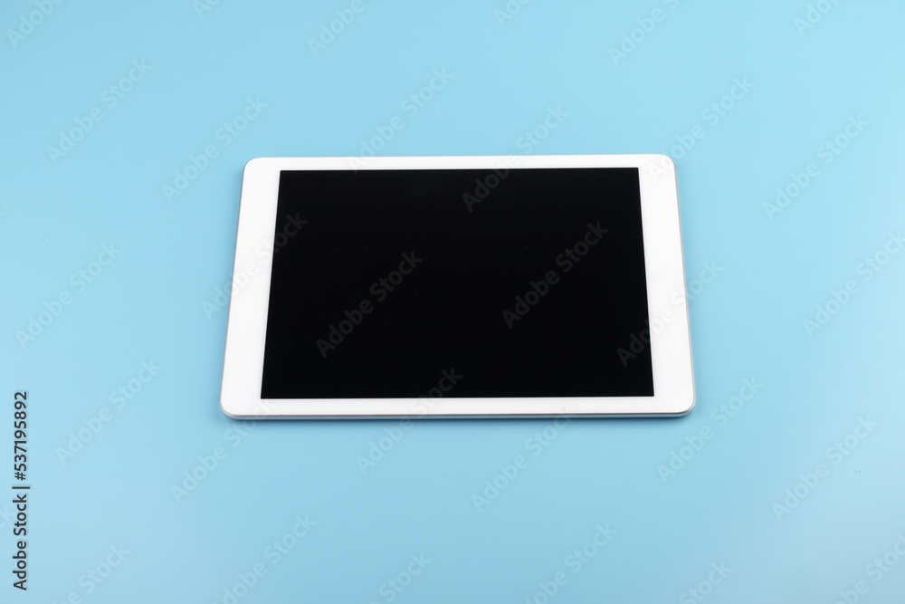 Top view of tablet on the blue pastel color background. Top view of tablet on the blue pastel color background.
