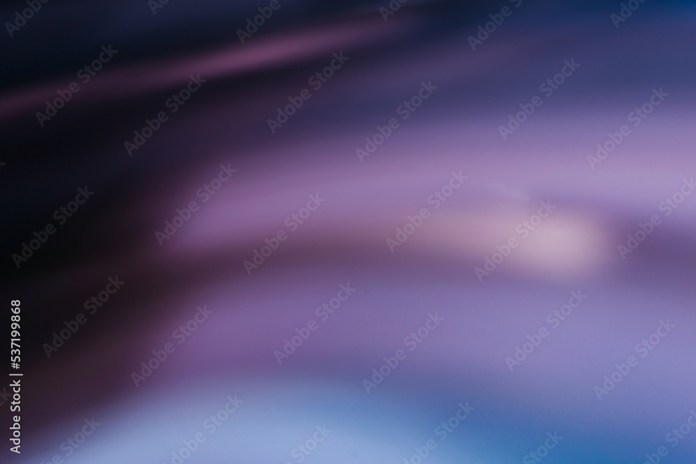 Defocused glow background. Light leak. Fluorescent flecks. Blur neon purple blue color smooth rays texture on dark black abstract free space poster.