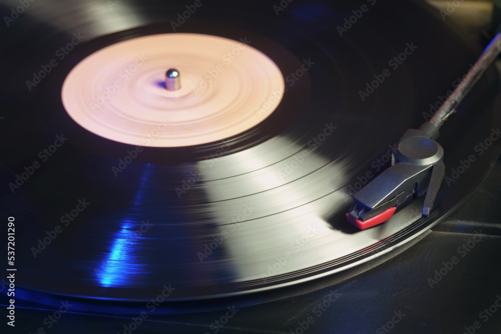 Detail of a retro record player with a spinning black vinyl record Detail of a retro record player with a spinning black vinyl record