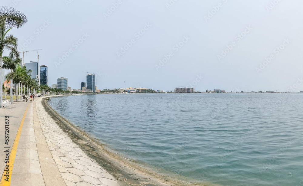 Panoramic view at the Luanda bay and Luanda marginal, pedestrian pathway with tropical palm trees, downtown lifestyle, Cabo Island, Port of Luanda and modern skyscrapers Panoramic view at the Luanda bay and Luanda marginal, pedestrian pathway with tropical palm trees, downtown lifestyle, Cabo Island, Port of Luanda and modern skyscrapers