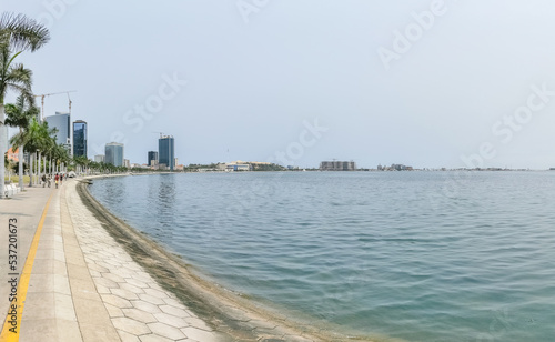 Panoramic view at the Luanda bay and Luanda marginal, pedestrian pathway with tropical palm trees, downtown lifestyle, Cabo Island, Port of Luanda and modern skyscrapers