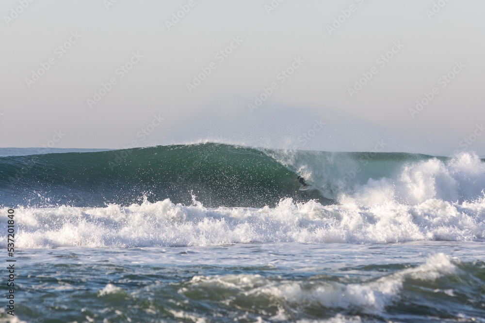 surfer getting barrelled on a wave 