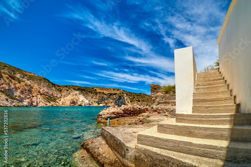 Stairs to azure sea waters of remote bay on Greek island on summer day