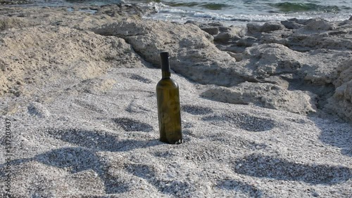 Bottle of wine on the rocky seashore. Caspian Sea. 07 June 2022 Year.