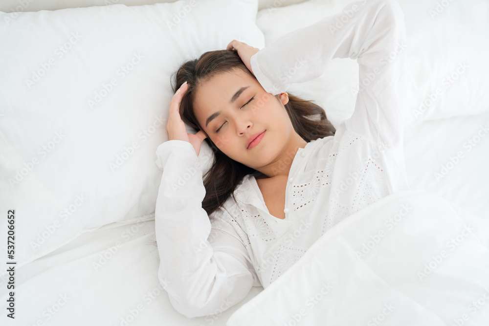 girl lying in bed unwell suffers from insomnia headache.Anxiety, holding your head girl lying in bed unwell suffers from insomnia headache.Anxiety, holding your head