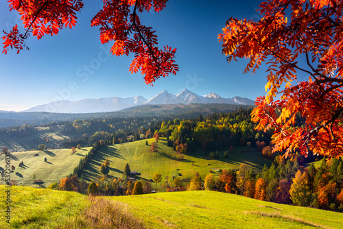 Beautiful autumn with a red and yellow trees under the Tatra Mountains at sunrise. Slovakia