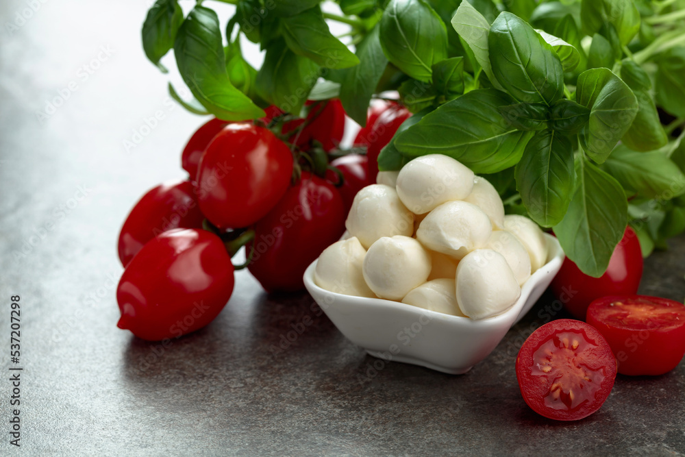 Mozzarella cheese with basil and tomatoes on an old stone table. Mozzarella cheese with basil and tomatoes on an old stone table.