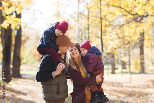 happy family Mom, dad and two little kids playing in autumn outdoor. family spends time together