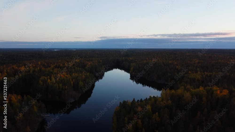Reverse ascending over a glass like lake sourounded by verdant autumn forest Reverse ascending over a glass like lake sourounded by verdant autumn forest