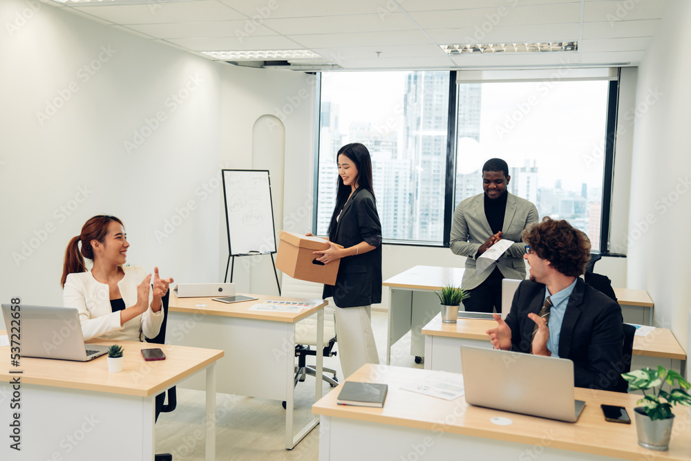 Beautiful young female carrying office box, hired for a new job, multiethnic colleagues welcome and smile, welcoming new worker Beautiful young female carrying office box, hired for a new job, multiethnic colleagues welcome and smile, welcoming new worker
