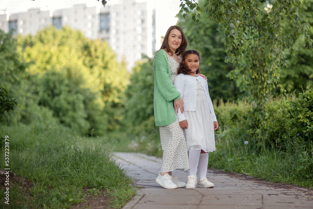 happy family mother and child daughter in nature park in summer on green grass. happy family mother and child daughter in nature park in summer on green grass.