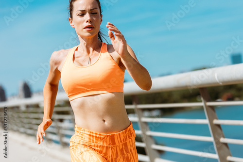 Fit fitness woman running outside over bridge. Healthy lifestyle concept