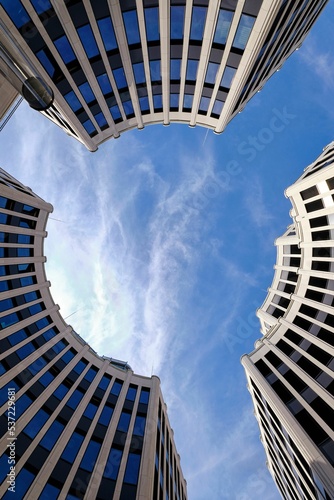 Canvastavla Low angle shot of urban circular round buildings with windows  under blue sky wi