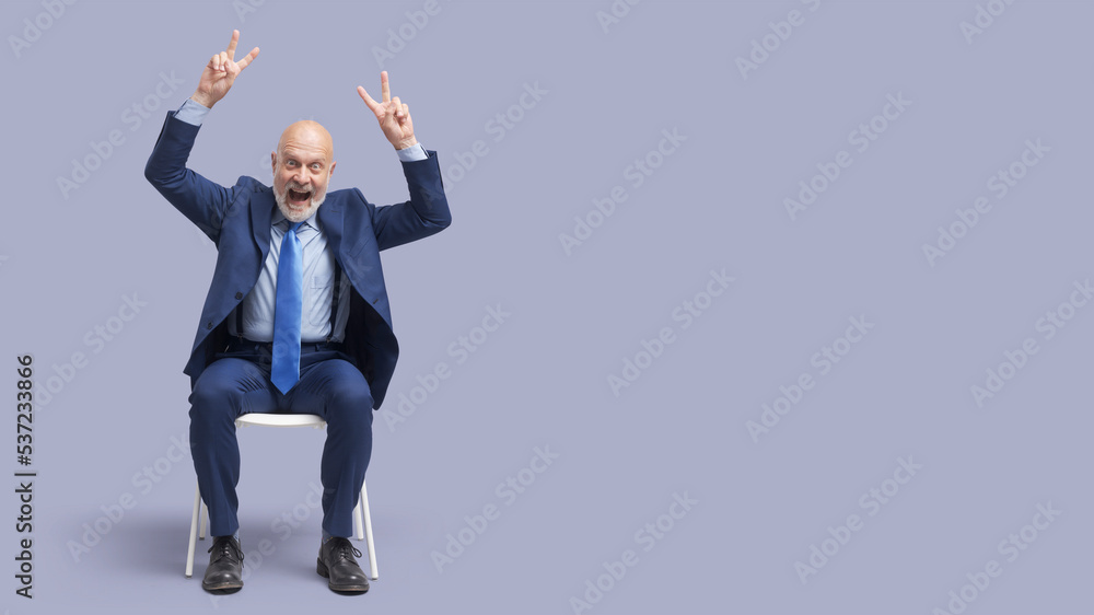 Successful businessman making V signs Successful businessman making V signs