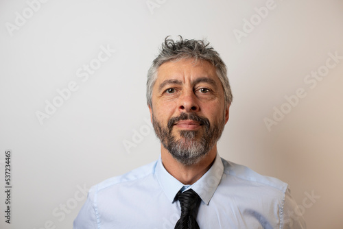 Portrait d'un homme d'affaires sympathique de 50 ans, souriant, portant une chemise et une cravate. Symbole de réussite professionnelle