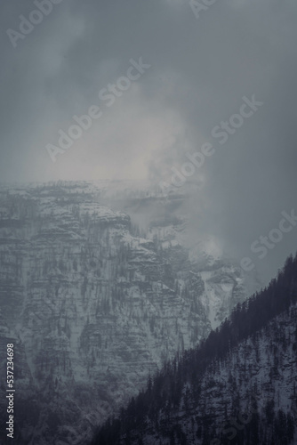 Mountain range with strong atmosphere during a snowy, dark winter afternoon