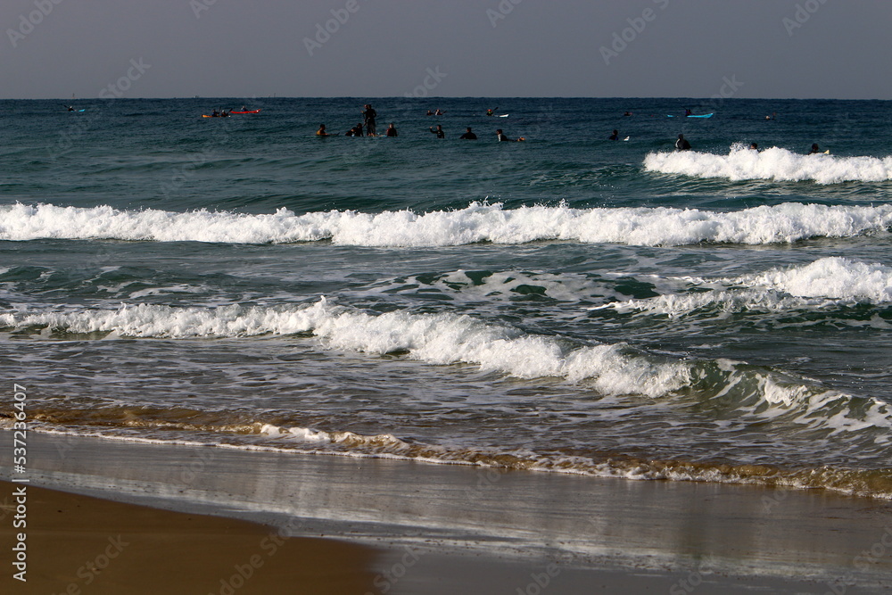 Surfing on high waves on the Mediterranean Sea in northern Israel.