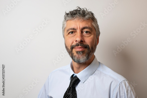 Portrait d'un homme d'affaires sympathique de 50 ans, souriant, portant une chemise et une cravate. Symbole de réussite professionnelle