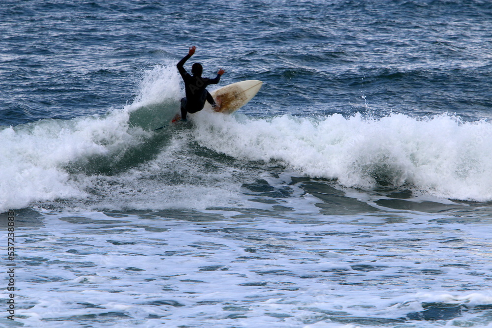 Surfing on high waves on the Mediterranean Sea in northern Israel.