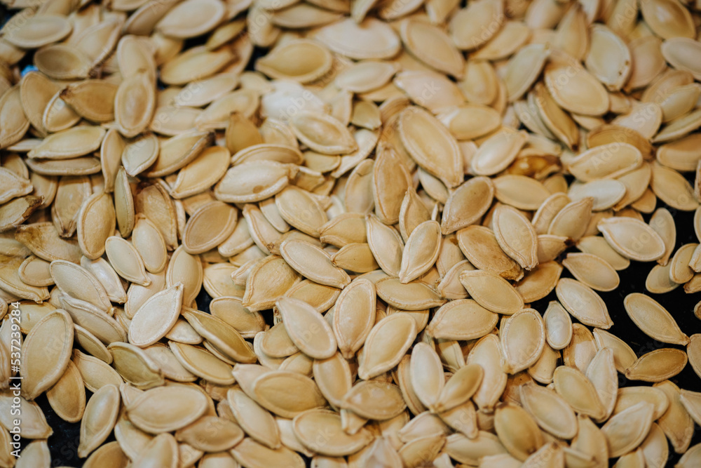 Scattered across the baking sheet roasted pumpkin seeds in shell Scattered across the baking sheet roasted pumpkin seeds in shell
