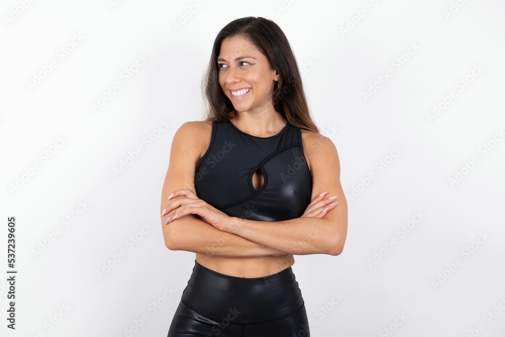 Dreamy rest relaxed young beautiful woman wearing sportswear over white background crossing arms, looks good copyspace Dreamy rest relaxed young beautiful woman wearing sportswear over white background crossing arms, looks good copyspace